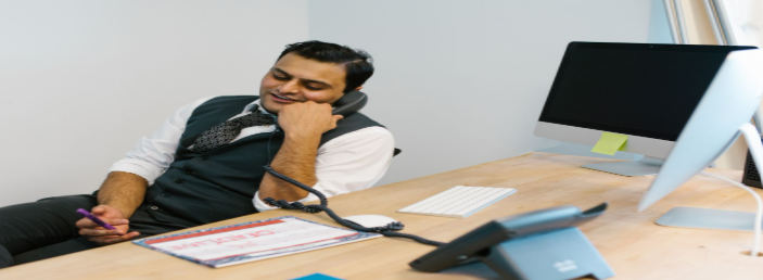 A man talking on the telephone at a desk, the first call most families make to bail agents in Cleveland